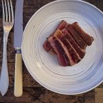 Grillad entrecôte skivad på rustik tallrik, rosa i mitten