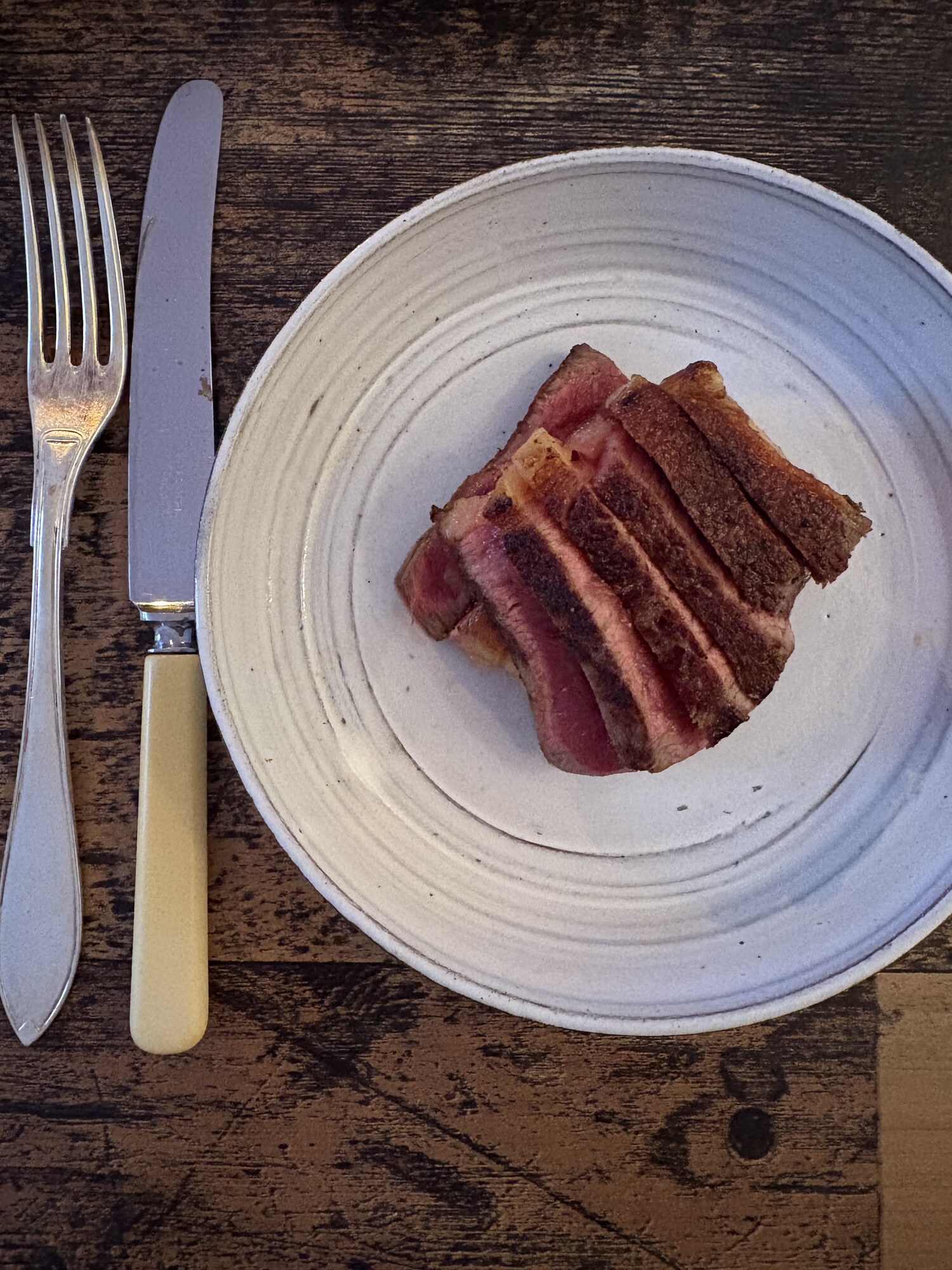 Grillad entrecôte skivad på rustik tallrik, rosa i mitten