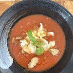 Gazpacho med getostkräm, krutonger och basilika i svart skål