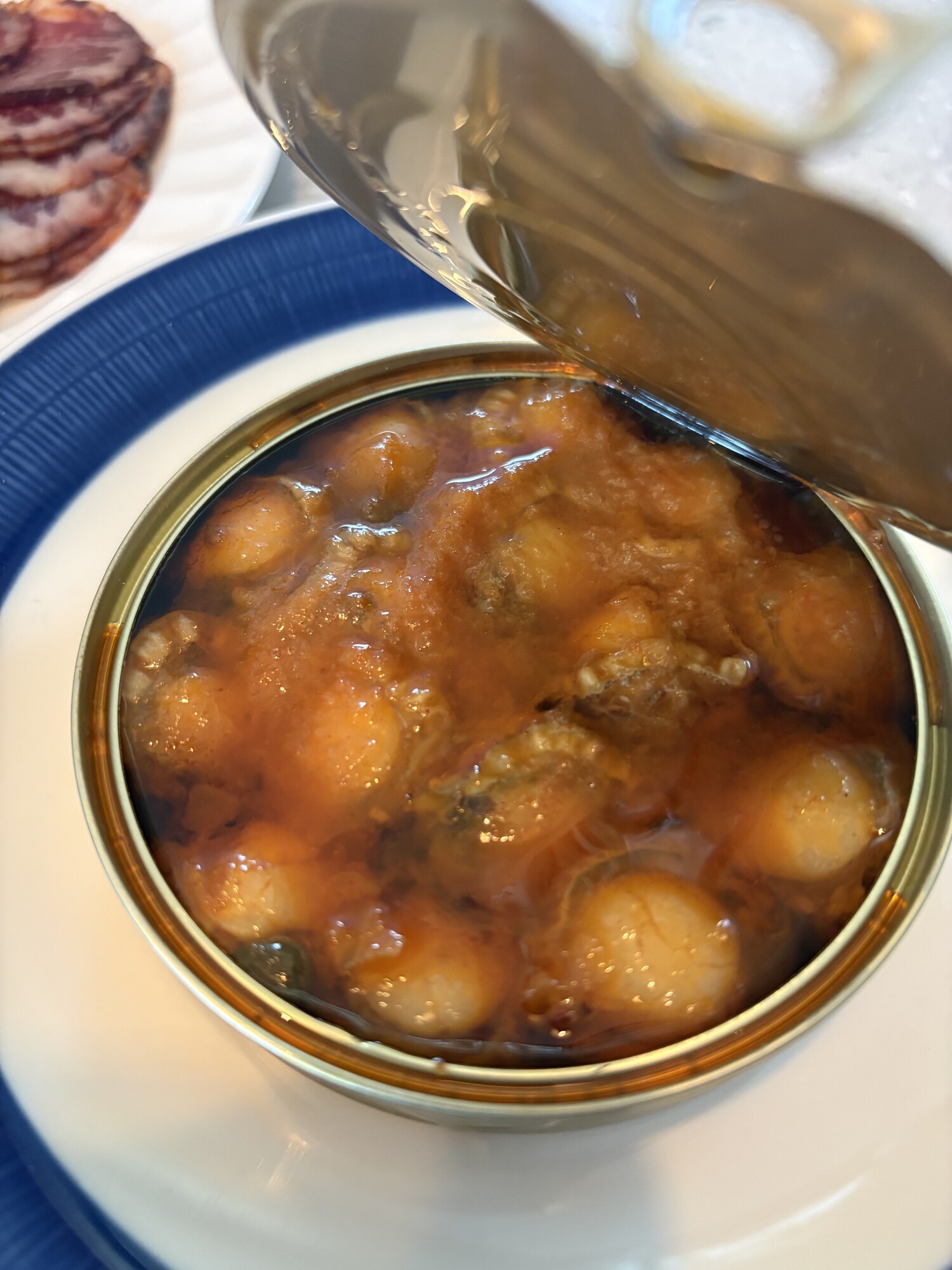 Öppnad burk Ramón Peña Zamburiñas Guisadas med kammusslor i galicisk tomatsås