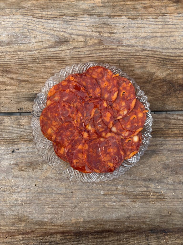 Skivad chorizo ibérico de bellota upplagd på glasfat