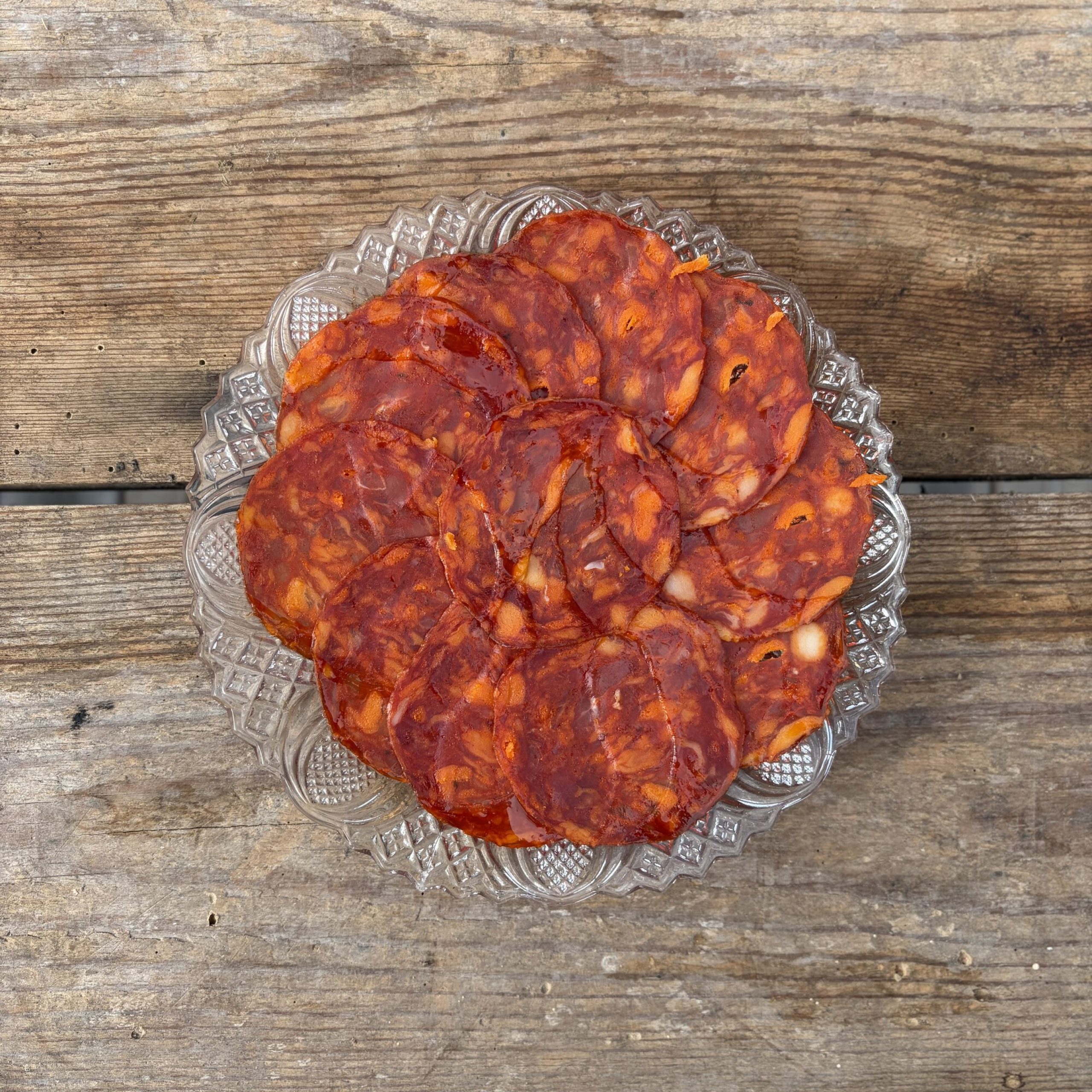 Skivad chorizo ibérico de bellota upplagd på glasfat