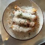 Friterade majshalvor täckta med finriven manchego, pimentón och gräslök i en skål
