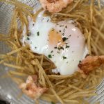 Huevos Rotos med pocherat ägg, friterad strimlad potatis och räkor