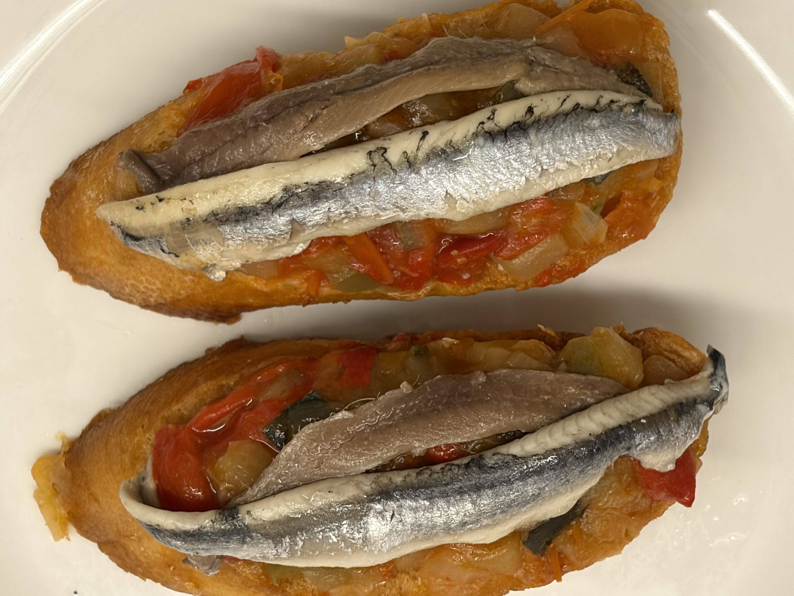 Matrimonio på piperrada, två pintxos med anchoa och boquerón på rostat bröd