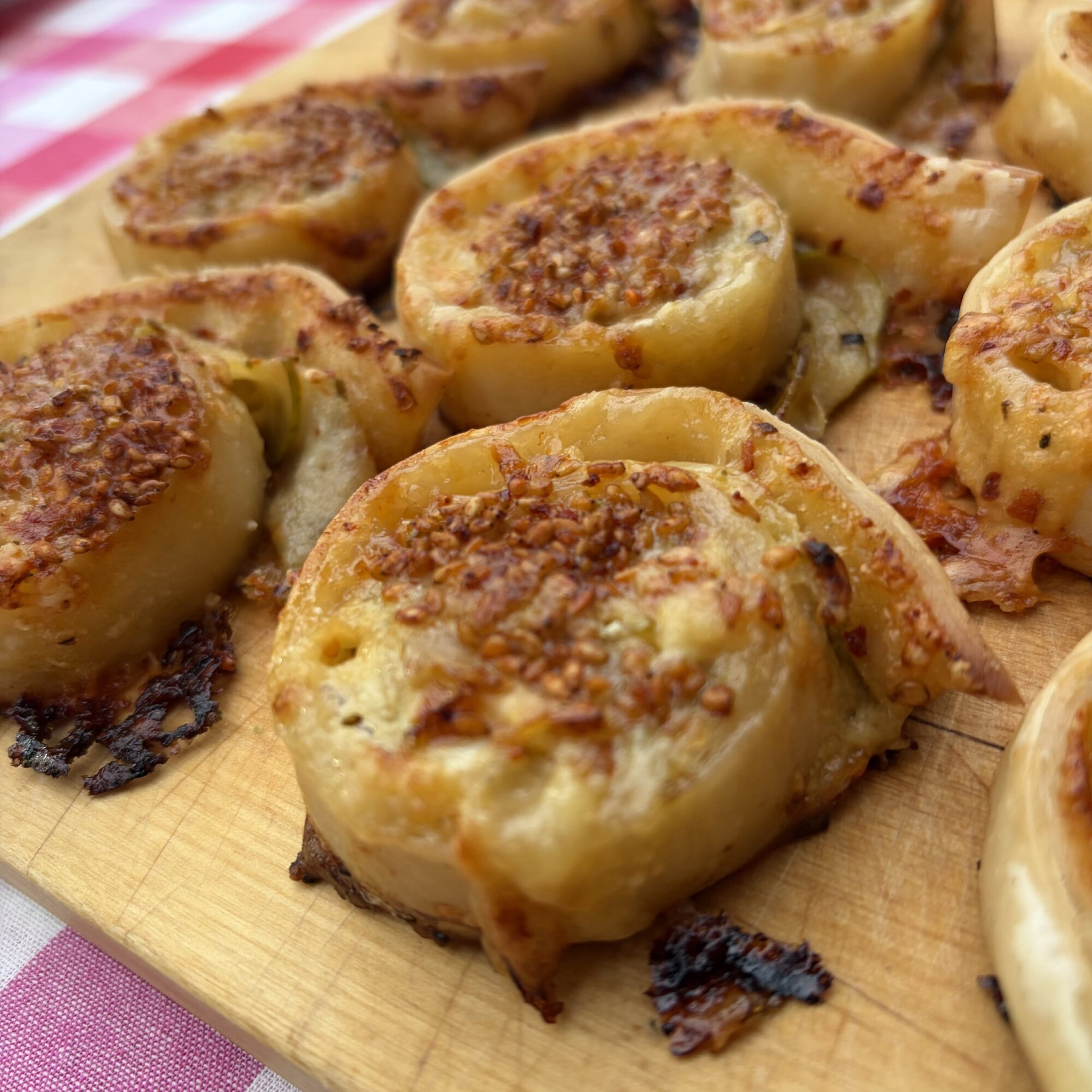 Smördegssnurror med päron, Manchego och sesam på skärbräda