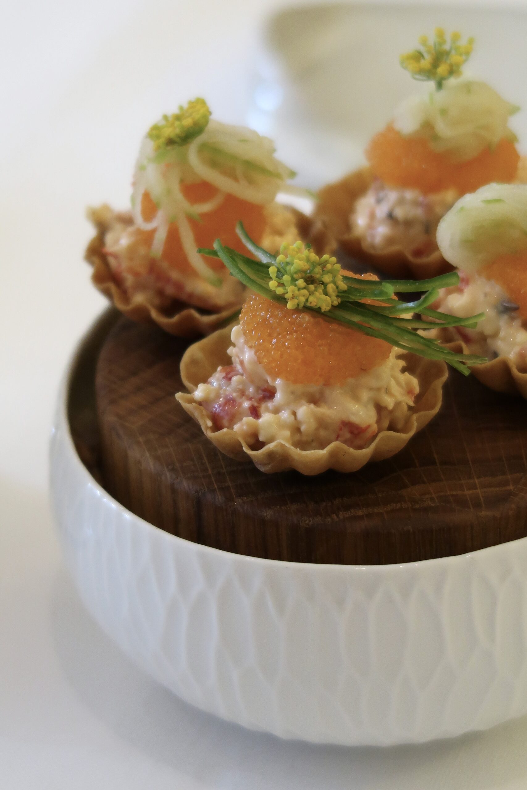 Krustader med kräftröra, rom och krondill på ett träfat
